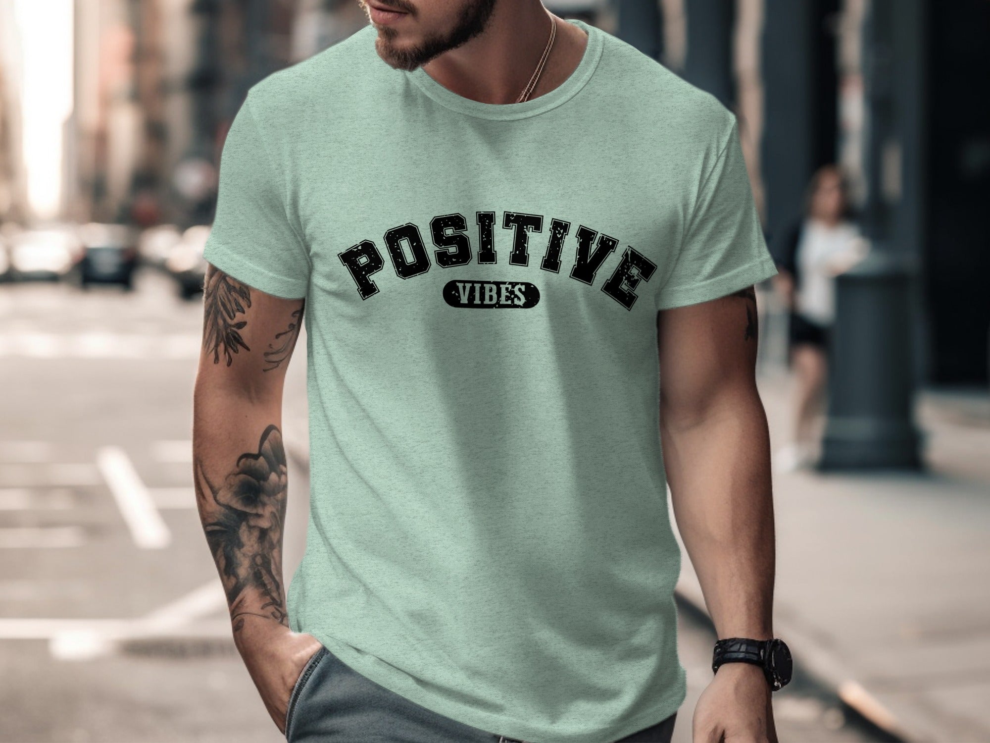 Man wearing a light green t-shirt with black text "POSITIVE VIBES"