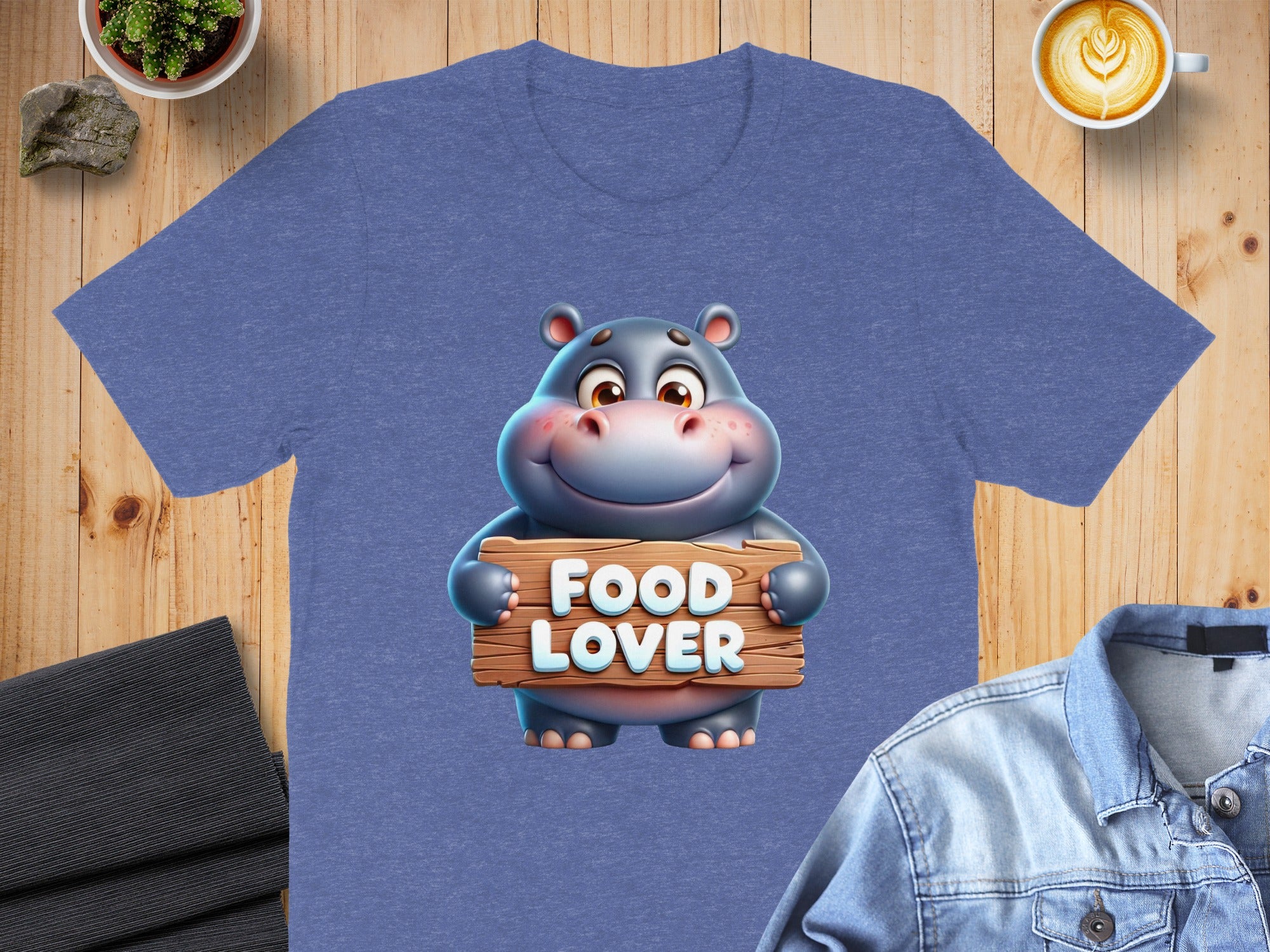 Cartoon hippo holds wooden sign reading "FOOD LOVER" on a t-shirt.