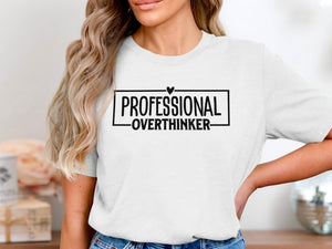 White t-shirt with black text: "PROFESSIONAL OVERTHINKER" inside a box.