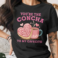 Black t-shirt with pink text "You're the Concha to my Cafecito" and heart-shaped concha.