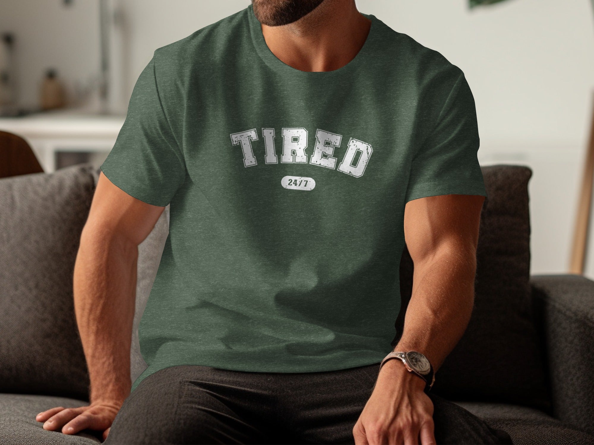 Green t-shirt with "TIRED 24/7" text, worn by a person sitting on a couch.