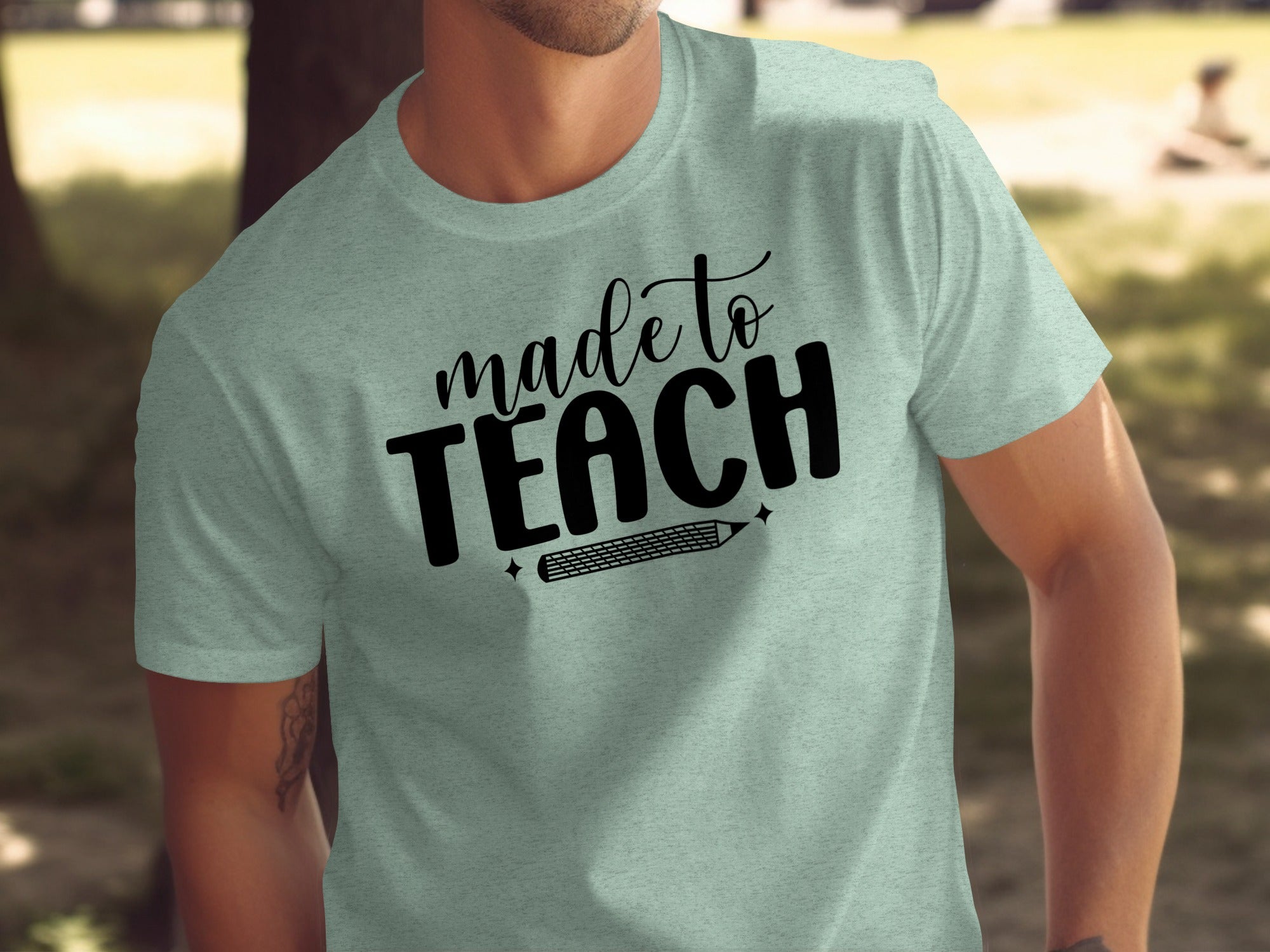 Light green t-shirt with "made to TEACH" text and a pencil graphic.
