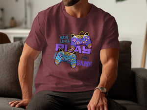Maroon t-shirt with graphic of cat-themed game controllers and text "New Level Play Game"