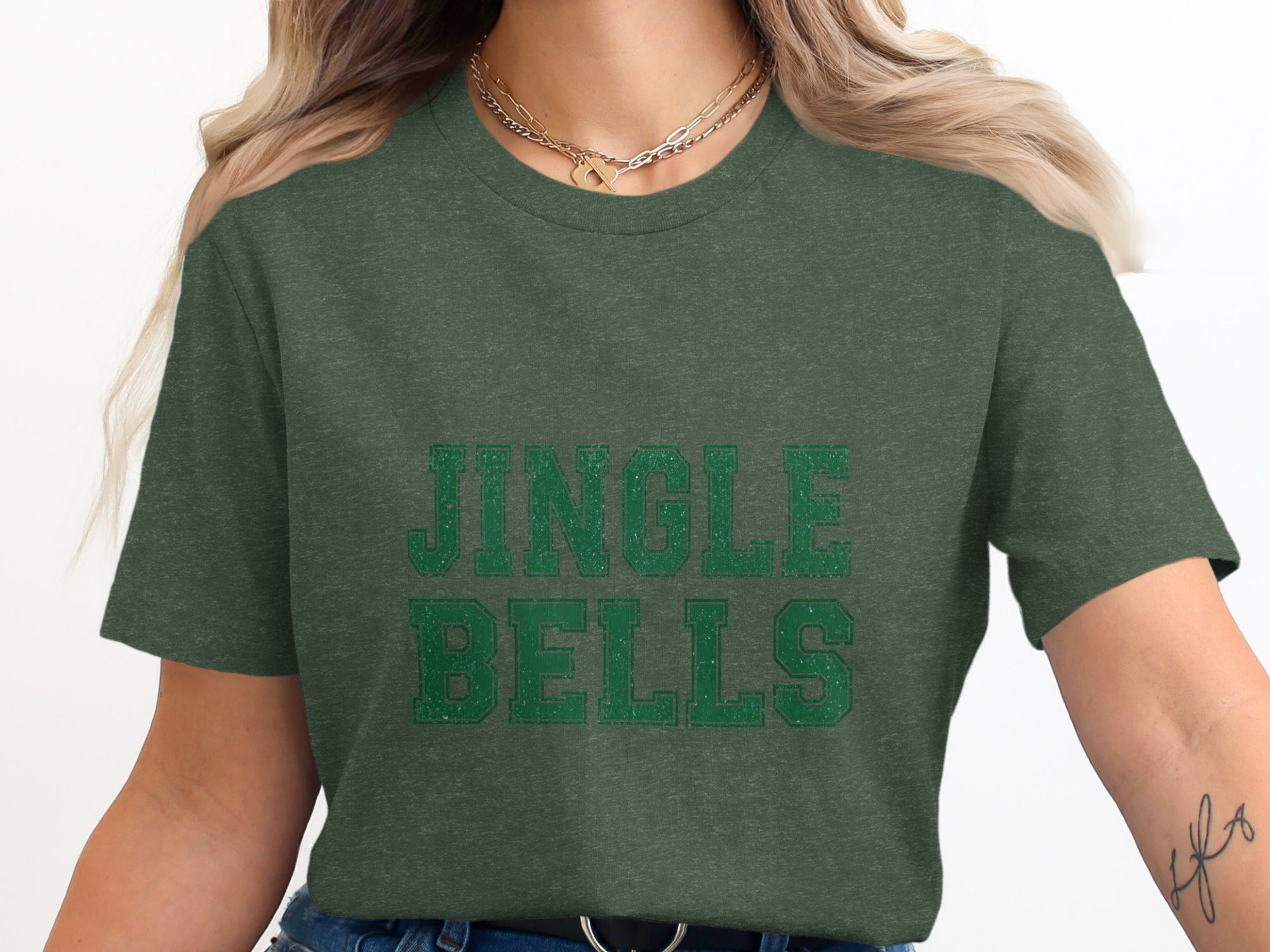 Green t-shirt with distressed "JINGLE BELLS" text in a collegiate font.