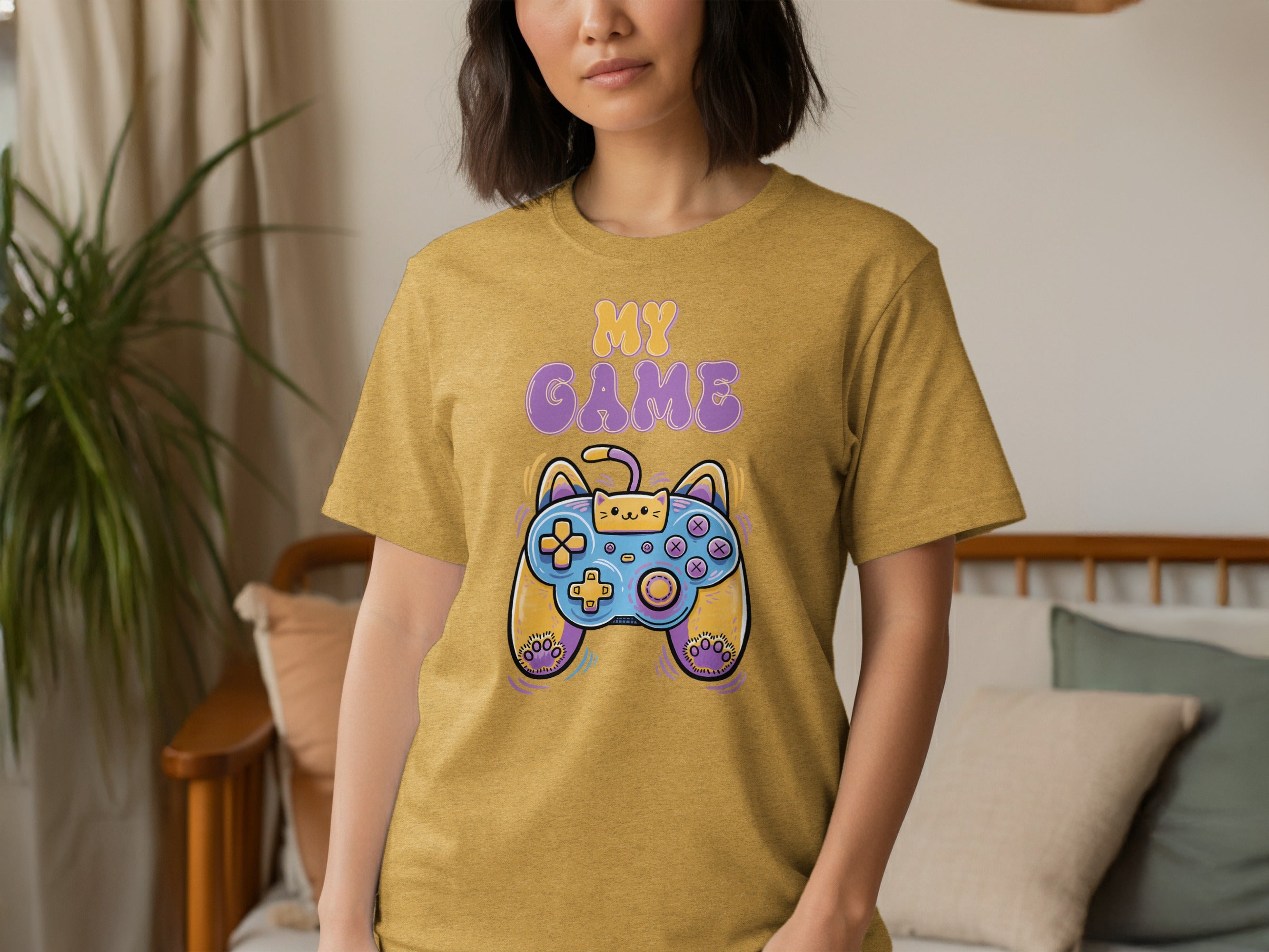 Mustard yellow t-shirt with purple and yellow text "MY GAME" and a cartoon cat gamepad.