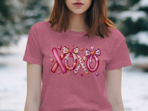 Pink t-shirt with "XOXO" text design featuring bows and hearts.