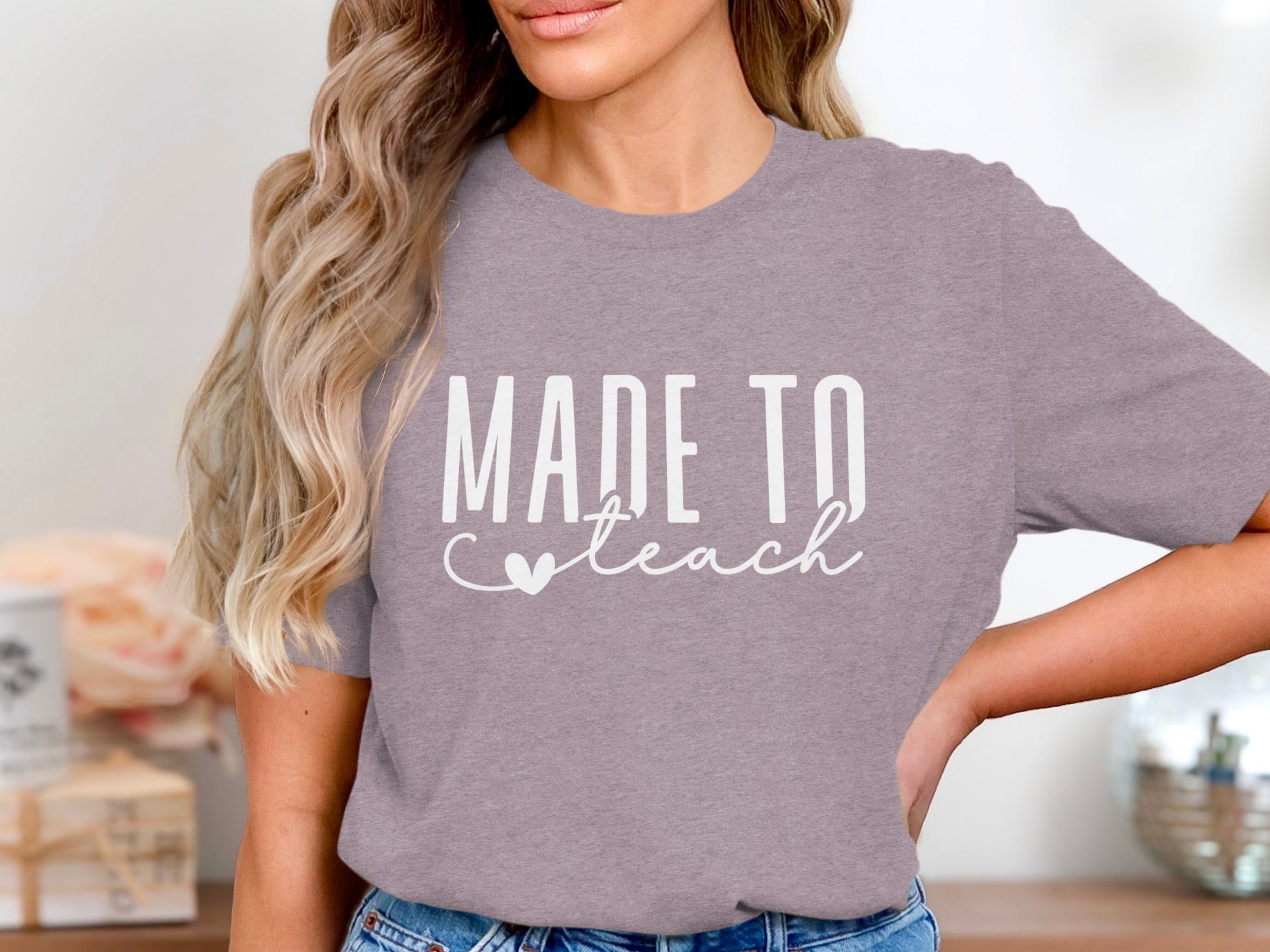 Lilac t-shirt with white text reading "MADE TO teach" and a heart.