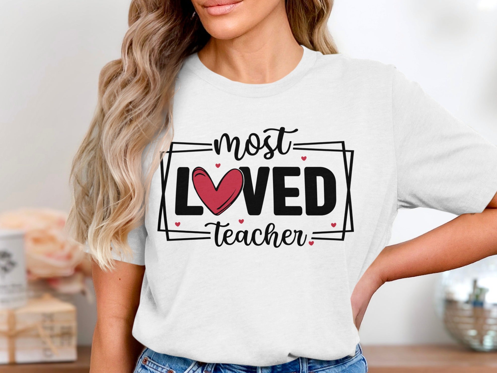 White t-shirt with "most LOVED Teacher" and red heart graphic.