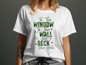 White t-shirt with green text "To the Window To the Wall I'm About To DECK These Halls".