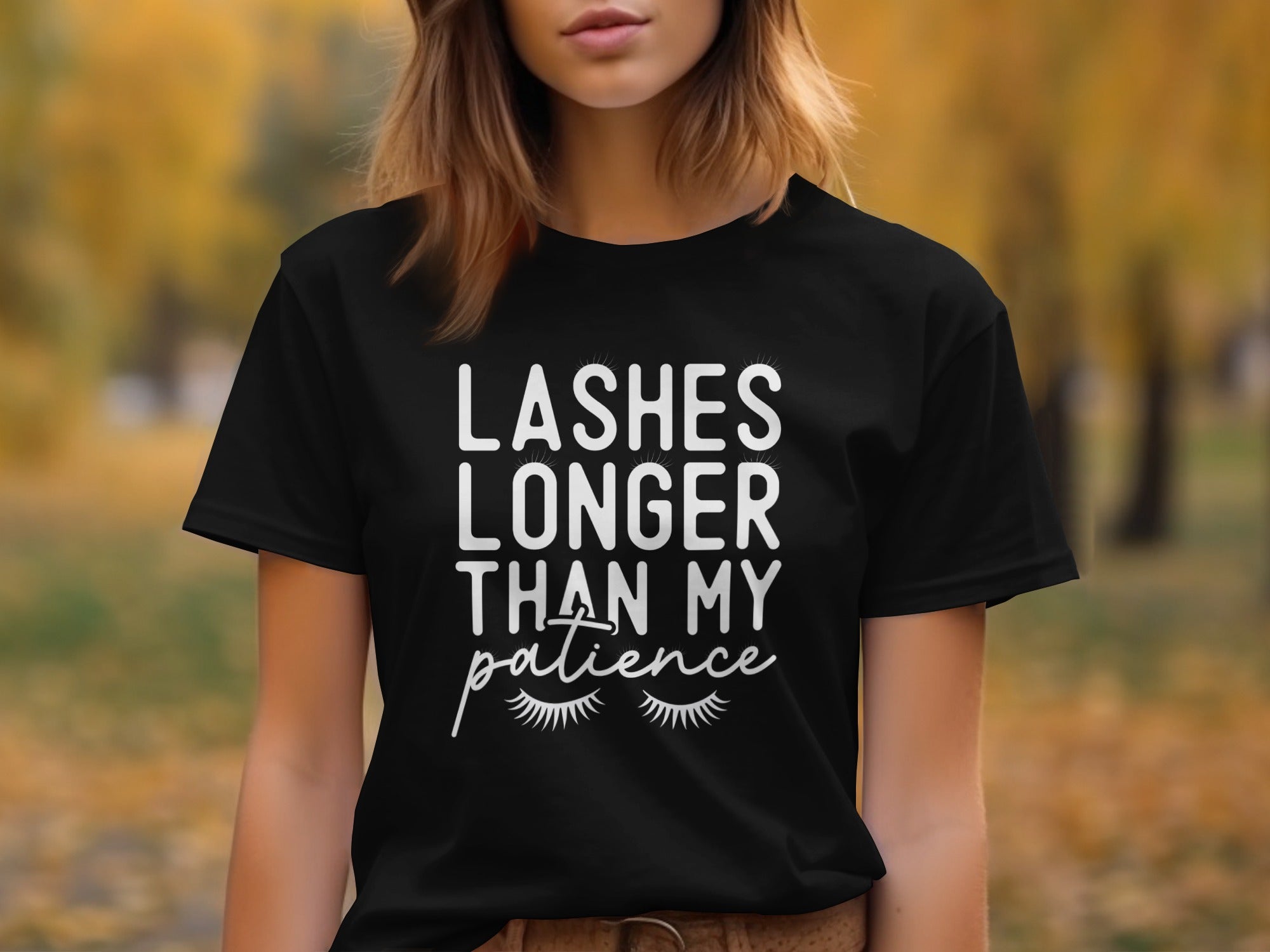 Black t-shirt with white text reading "Lashes Longer Than My Patience" and cartoon eyelashes.