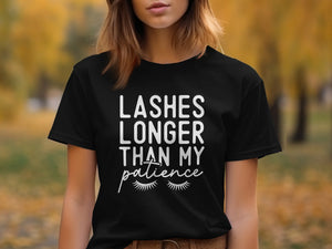Black t-shirt with white text reading "Lashes Longer Than My Patience" and cartoon eyelashes.