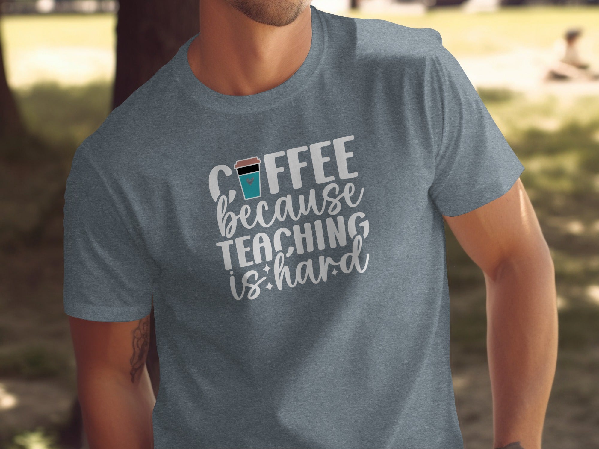 Heather grey t-shirt with white text "Coffee because teaching is hard".