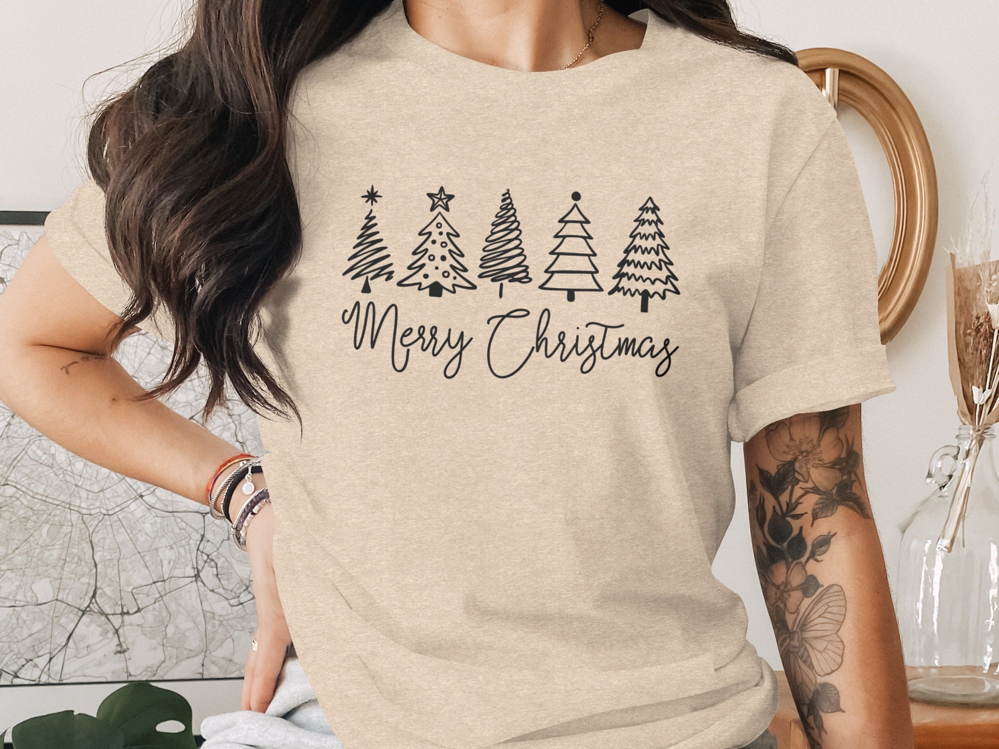 T-shirt with black line drawing of five Christmas trees and "Merry Christmas" text.