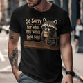 T-shirt graphic with raccoon holding coffee and text: "So sorry for what my wife's face said."
