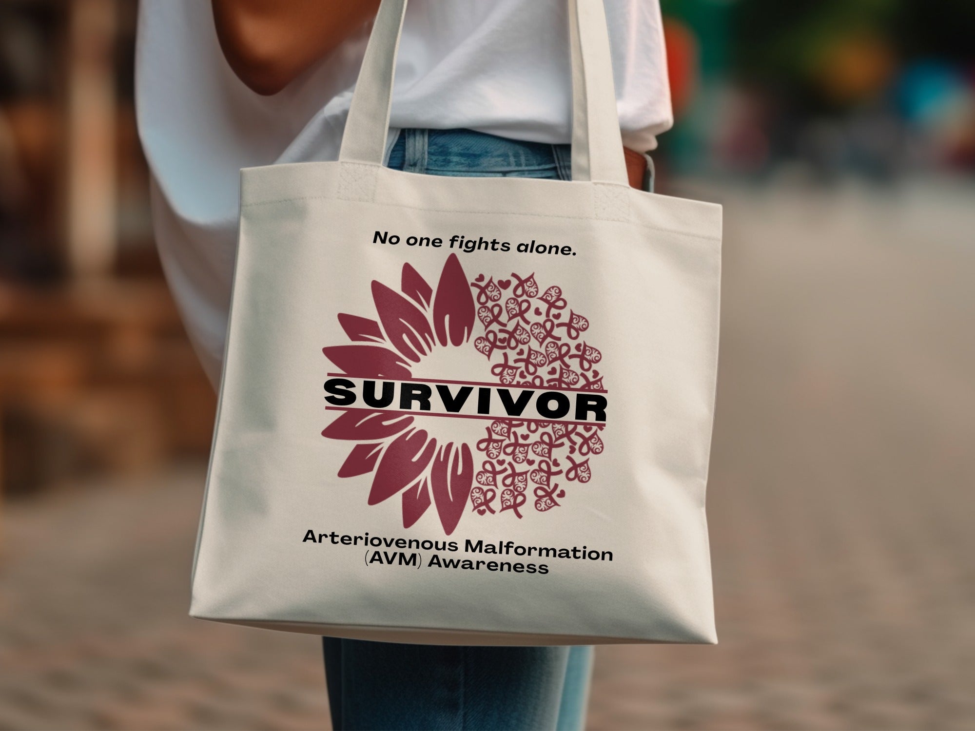 Tote bag with "Survivor" text, a sunflower graphic, and awareness ribbons.