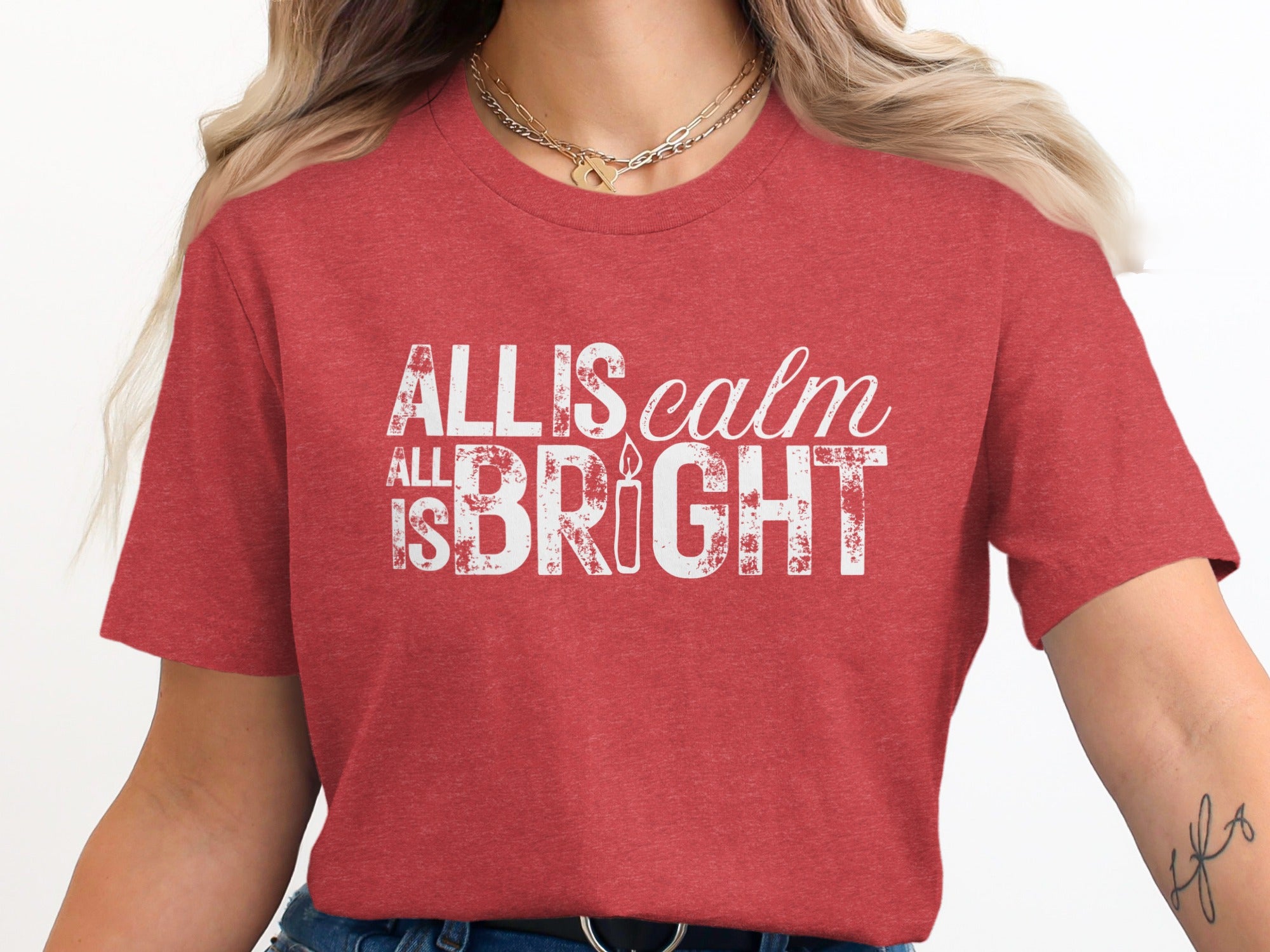 Red t-shirt with white distressed text "All is calm, All is bright" and a candle.