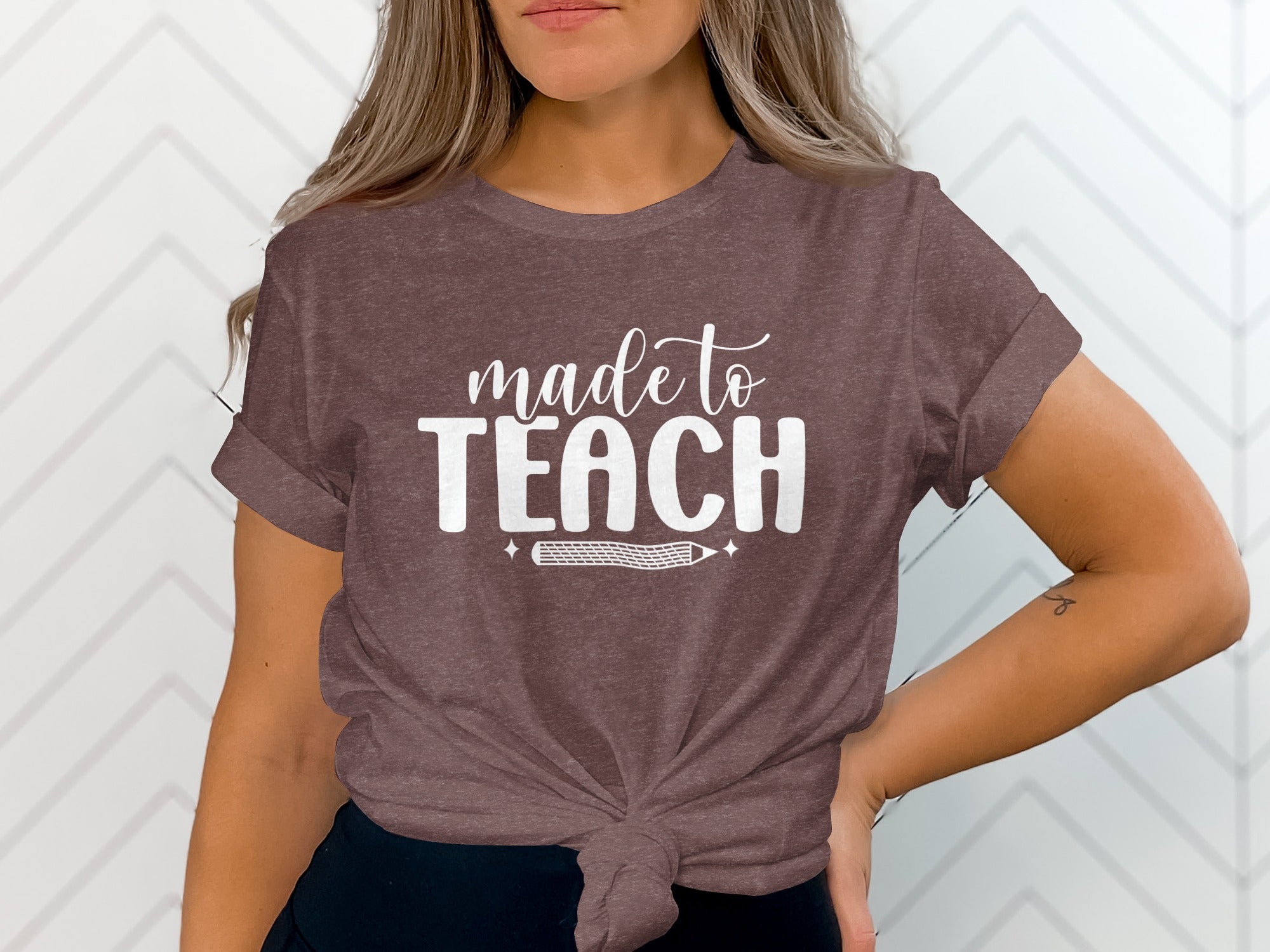 Brown t-shirt with white text that reads "made to TEACH" and a pencil graphic.