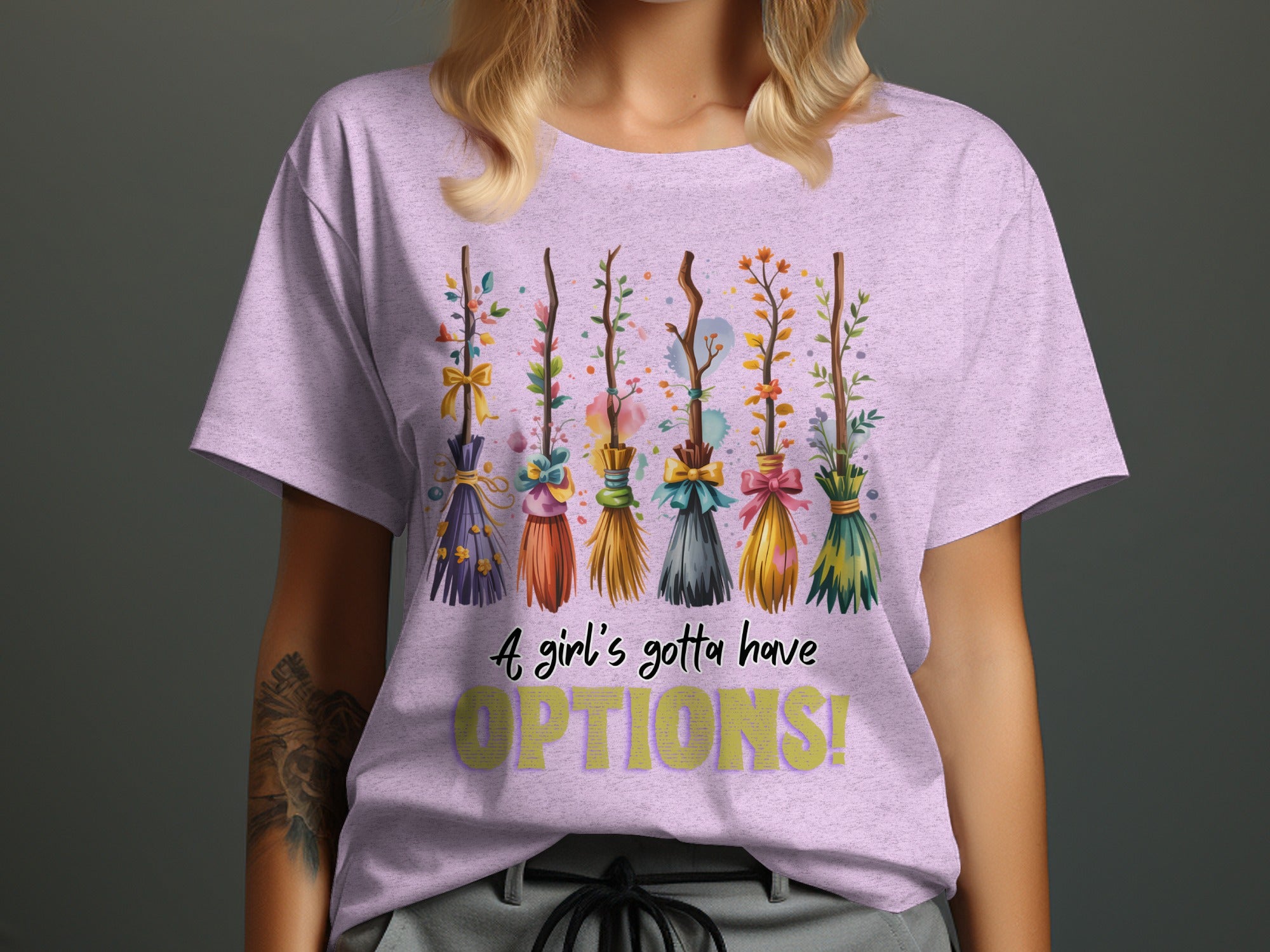 T-shirt with decorative broomsticks and text "A girl's gotta have OPTIONS!".