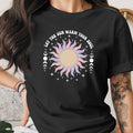 Black t-shirt with "LET THE SUN WARM YOUR SOUL" text and boho sun graphic.