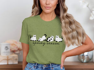 Green t-shirt with black ghost cats and "spooky season" text.
