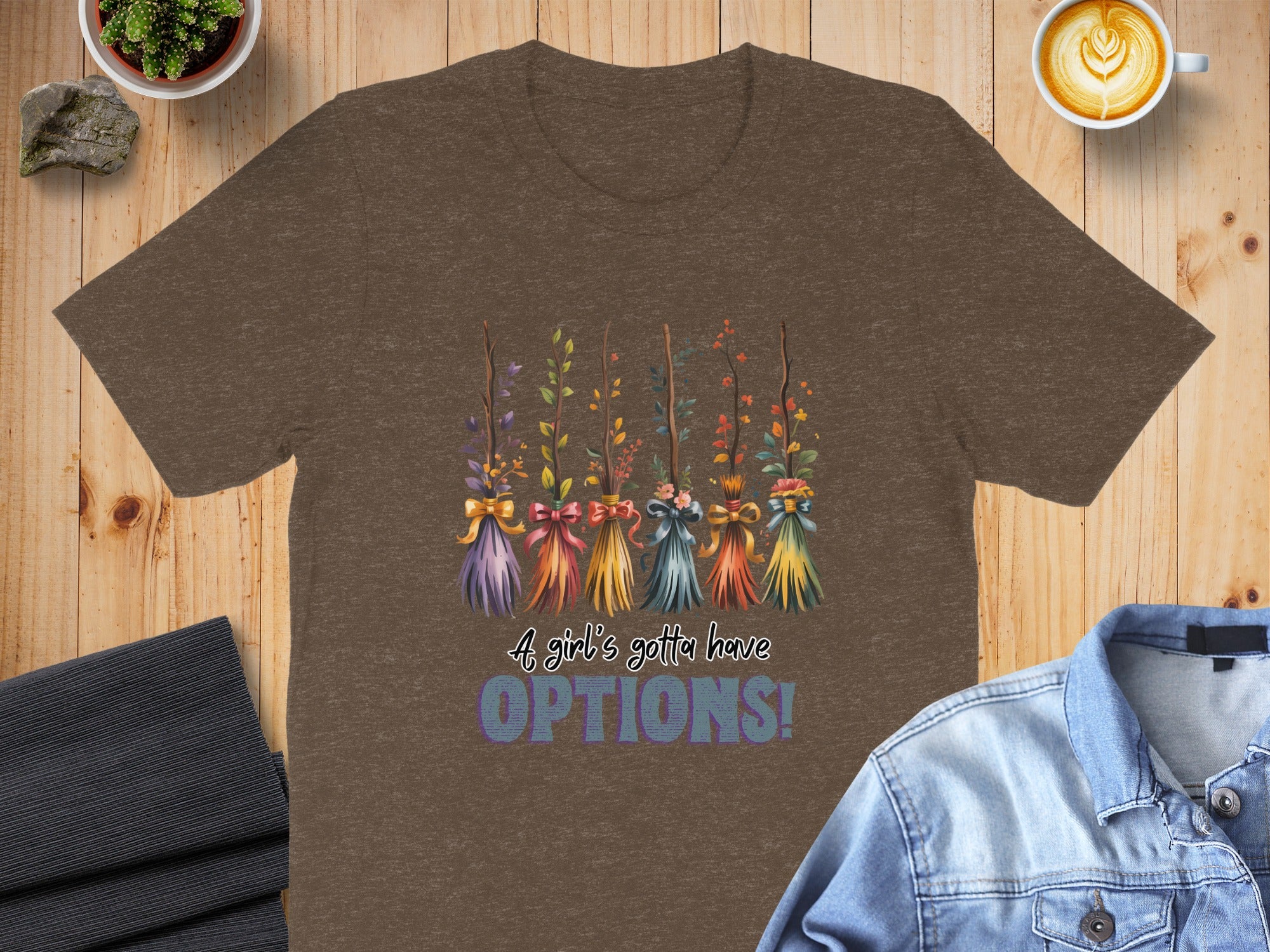 Brown t-shirt with five decorative brooms and text "A girl's gotta have OPTIONS!".