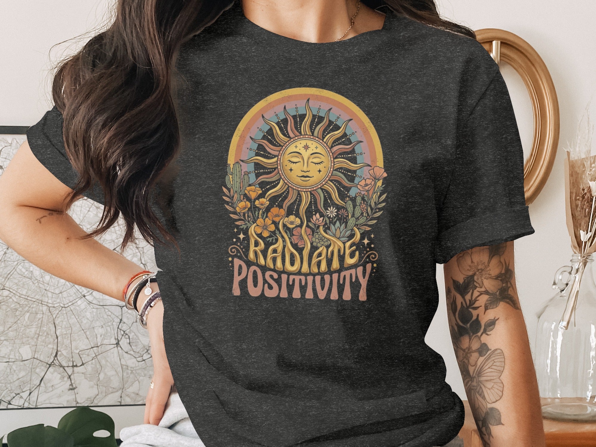 T-shirt with sun, rainbow, cacti, flowers, and "Radiate Positivity" text.