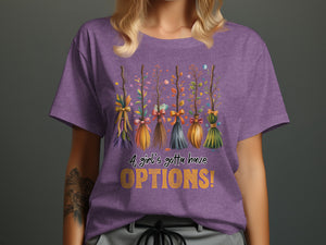 Purple t-shirt with five decorative brooms and text "A girl's gotta have OPTIONS!"