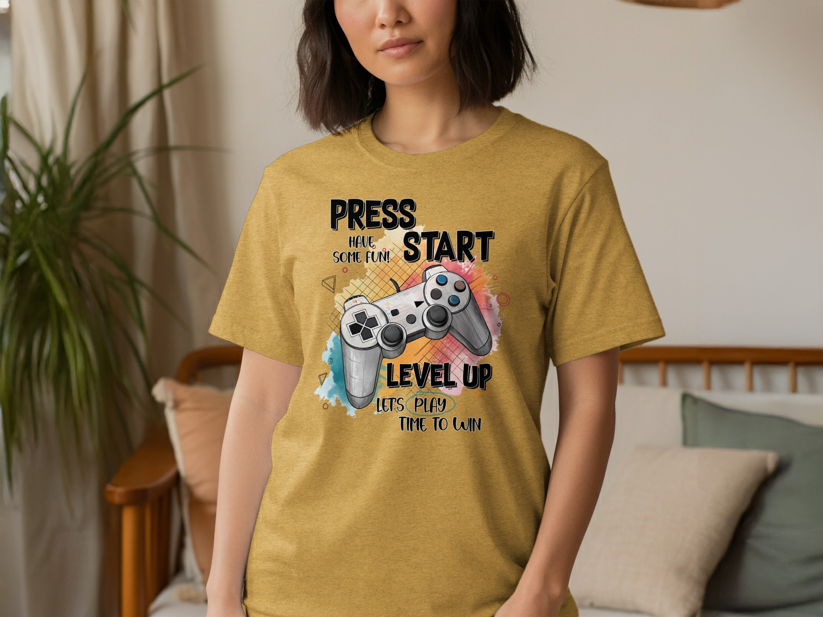 Gold t-shirt with "PRESS START HAVE SOME FUN! LEVEL UP" and game controller graphic.