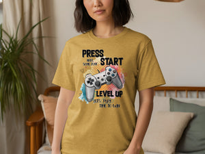 Gold t-shirt with "PRESS START HAVE SOME FUN! LEVEL UP" and game controller graphic.
