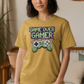 Yellow t-shirt with "GAME OVER GAMER" text and retro video game controller graphic.