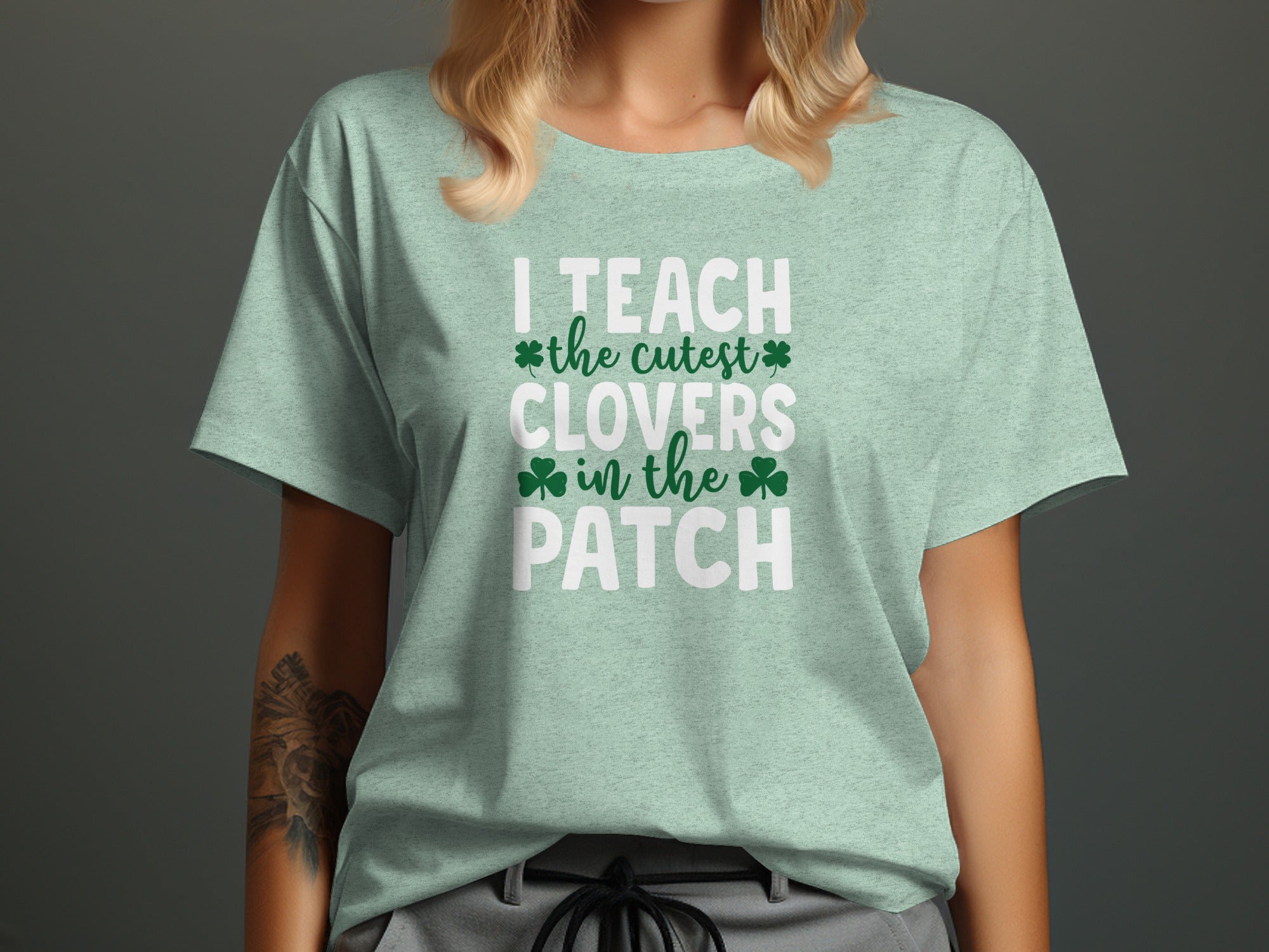 Light green t-shirt with white text "I TEACH the cutest CLOVERS in the PATCH".