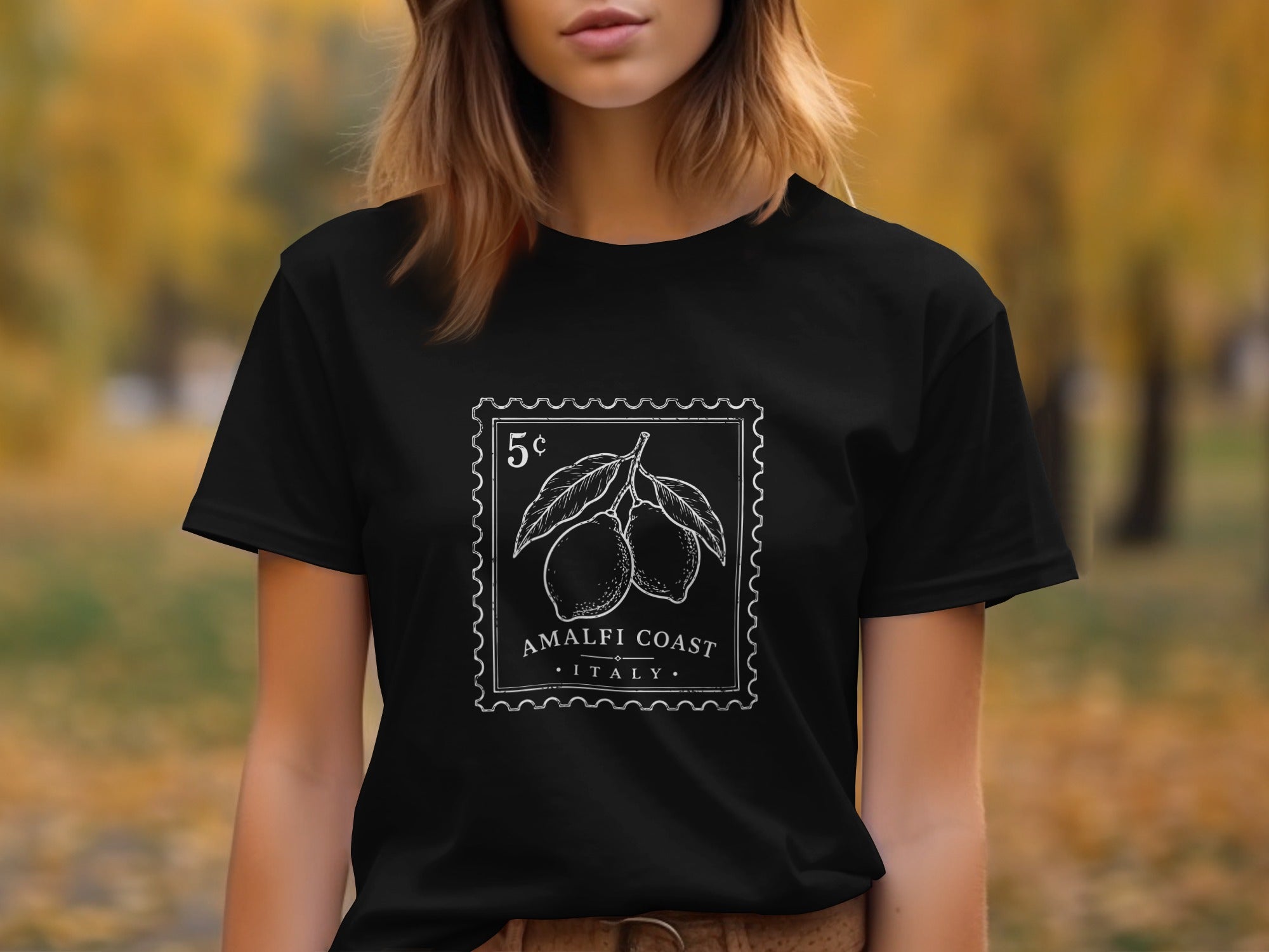 Black t-shirt with a white stamp design featuring lemons, "5¢", "AMALFI COAST", and "ITALY".