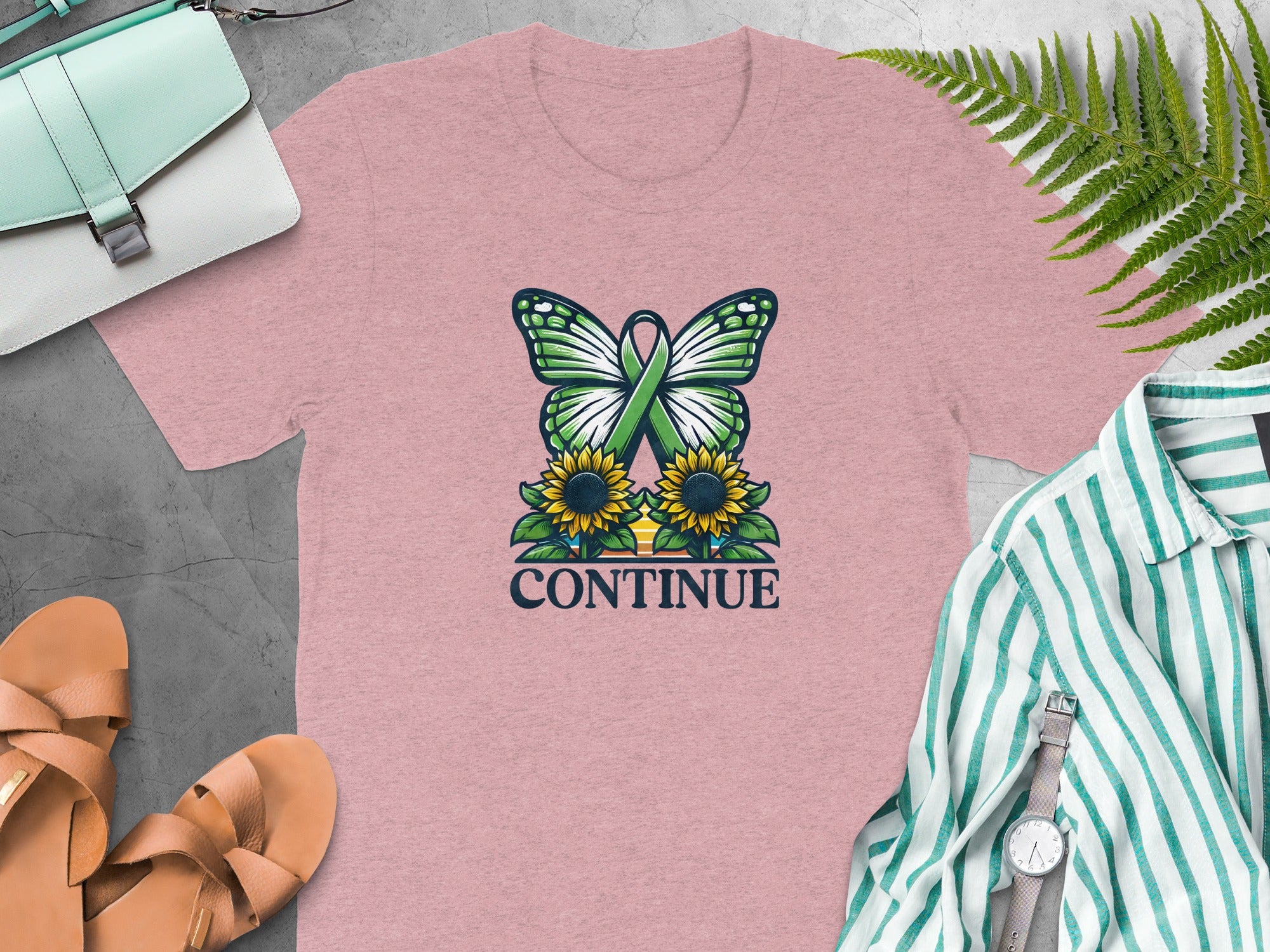 Pink t-shirt with butterfly, sunflowers, green ribbon, and text "CONTINUE".