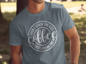 Grey t-shirt with a circular design that says "Coffee First I Drink The Then I Teach The Kids".