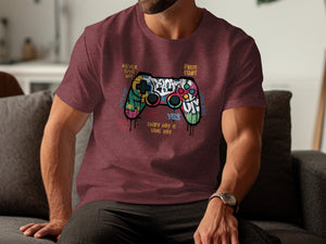 T-shirt with colorful graffiti-style video game controller and text.