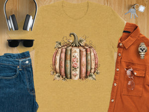 Yellow t-shirt with a pumpkin graphic made of antique books and floral accents.