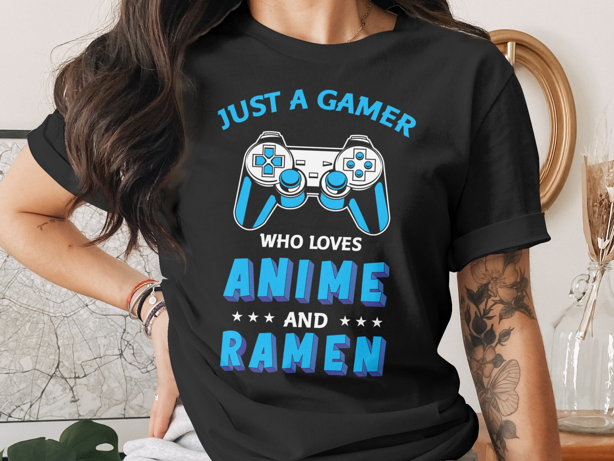 Black t-shirt with "JUST A GAMER WHO LOVES ANIME AND RAMEN" text and controller graphics.