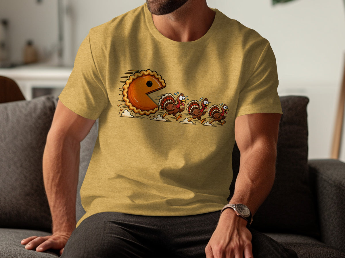 Pie character chasing cartoon turkeys on a yellow t-shirt.