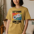 Yellow t-shirt with graphic: "LET'S HAVE SOME FUN! PRESS START" and a game controller.