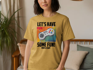 Yellow t-shirt with graphic: "LET'S HAVE SOME FUN! PRESS START" and a game controller.