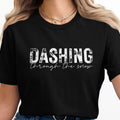 Black t-shirt with white text reading "DASHING through the snow."