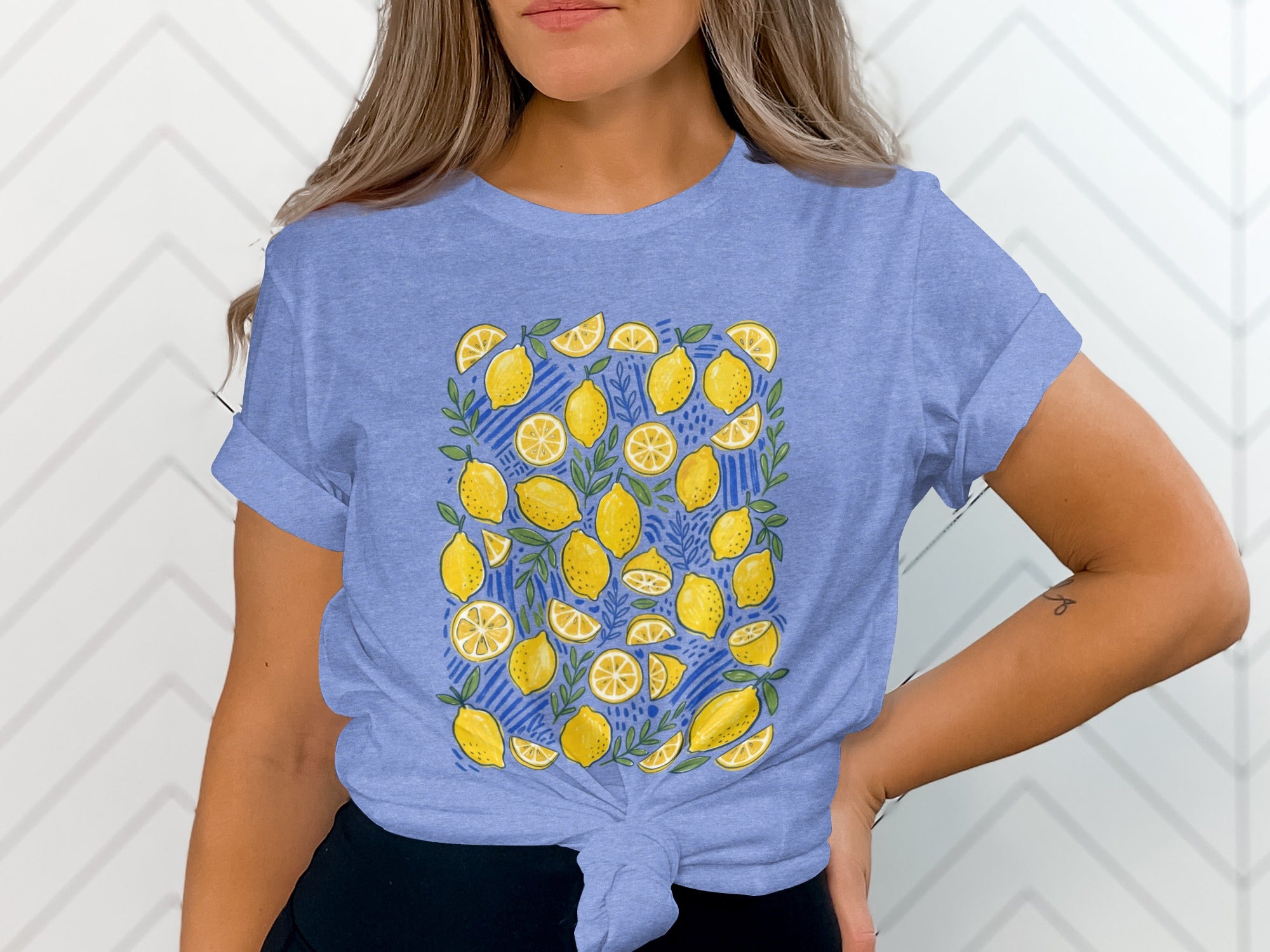 Blue t-shirt with a pattern of yellow lemons and green leaves on a blue striped background.