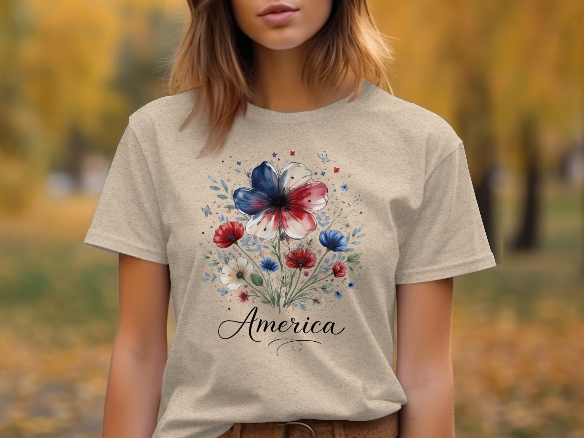 Light tan t-shirt with floral design featuring red, white, and blue flowers and the word "America".