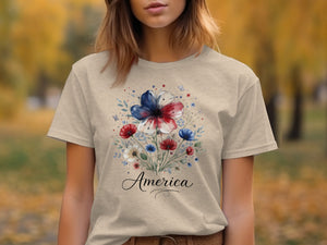 Light tan t-shirt with floral design featuring red, white, and blue flowers and the word "America".