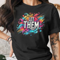 Black t-shirt with vibrant "LET THEM" graphic design and watercolor splashes.