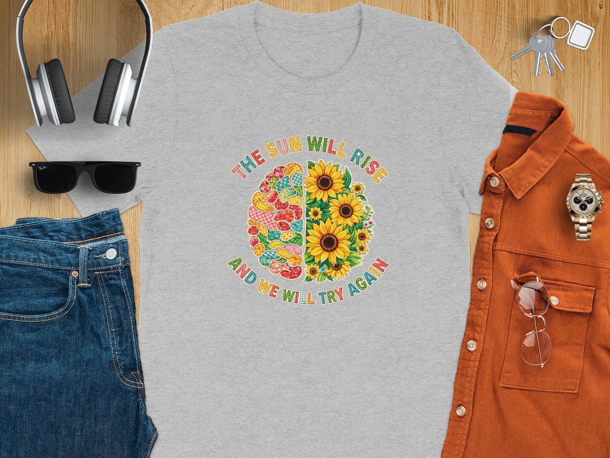 Gray t-shirt with "The Sun Will Rise" and sunflowers on the front.