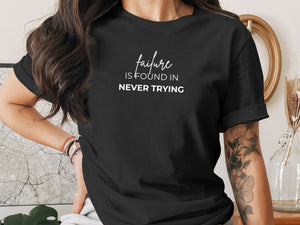 Black t-shirt with white text "failure is found in never trying".