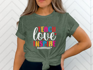 Olive green t-shirt with "Teach love inspire" text and pencil graphic.