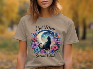 T-shirt with a black cat, moon, stars, and flowers. Text reads "Cat Mom Social Club".