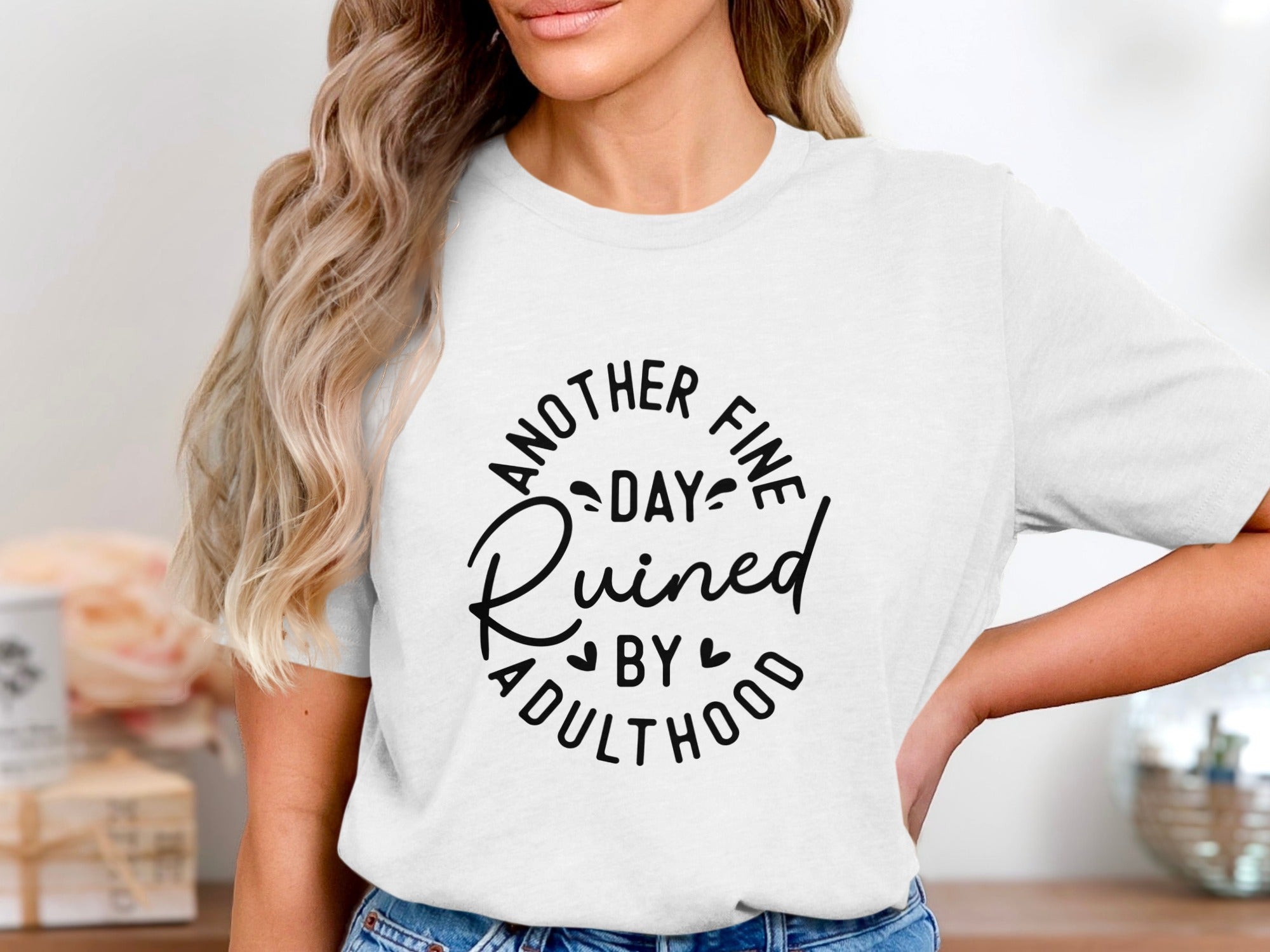 White t-shirt with black text that reads "Another Fine Day Ruined By Adulthood."